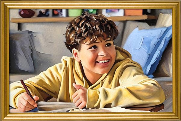 Young male with a big smile on his face sitting at a table drawing.