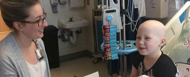 A caregiver does art therapy with a patient.