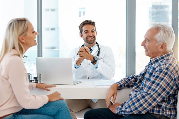 Cropped shot of a handsome male doctor consulting with a couple in his office