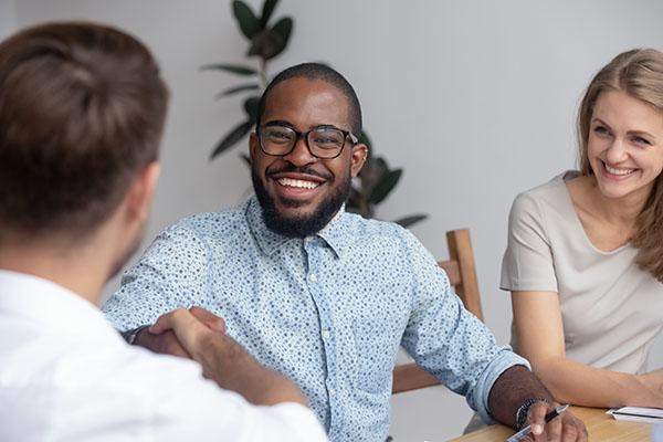 Happy African HR recruit manager handshake hire candidate at business interview, smiling black recruiter employer shake hand employ congratulate new worker made good first impression got job concept