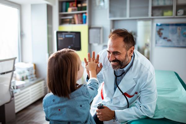 Close up of a young girl getting checked up in the doctor’s office.