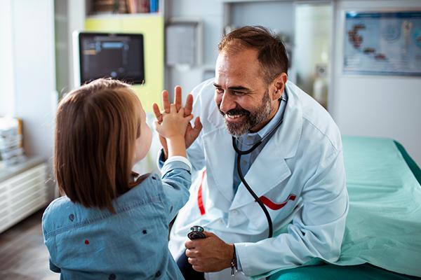 Close up of a young girl getting checked up in the doctor’s office.