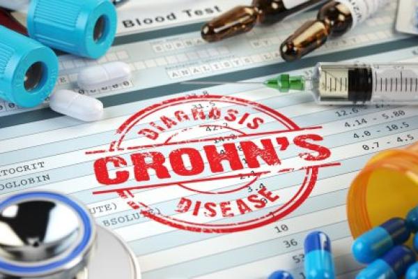 Graphic on Crohn’s disease diagnosis. Stamp, stethoscope, syringe, blood test and pills on the clipboard with medical report.