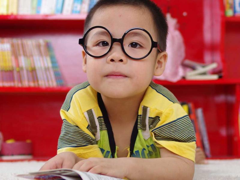 Boy standing near bookshelf
