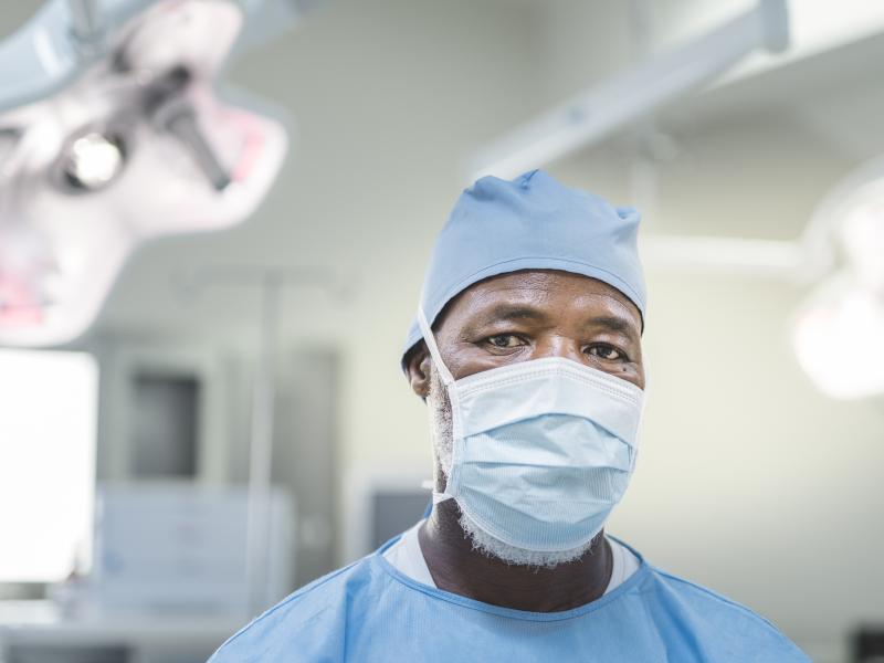 A health care professional wearing a mask looks at the camera.