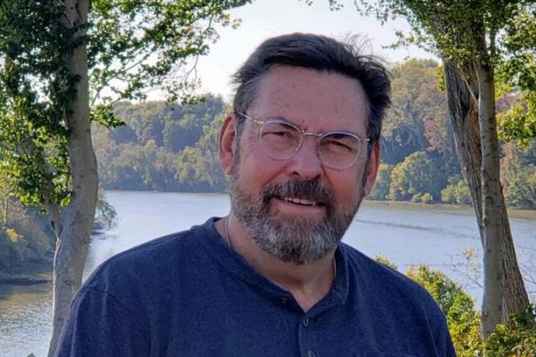 Gentleman smiling outdoors near a lake