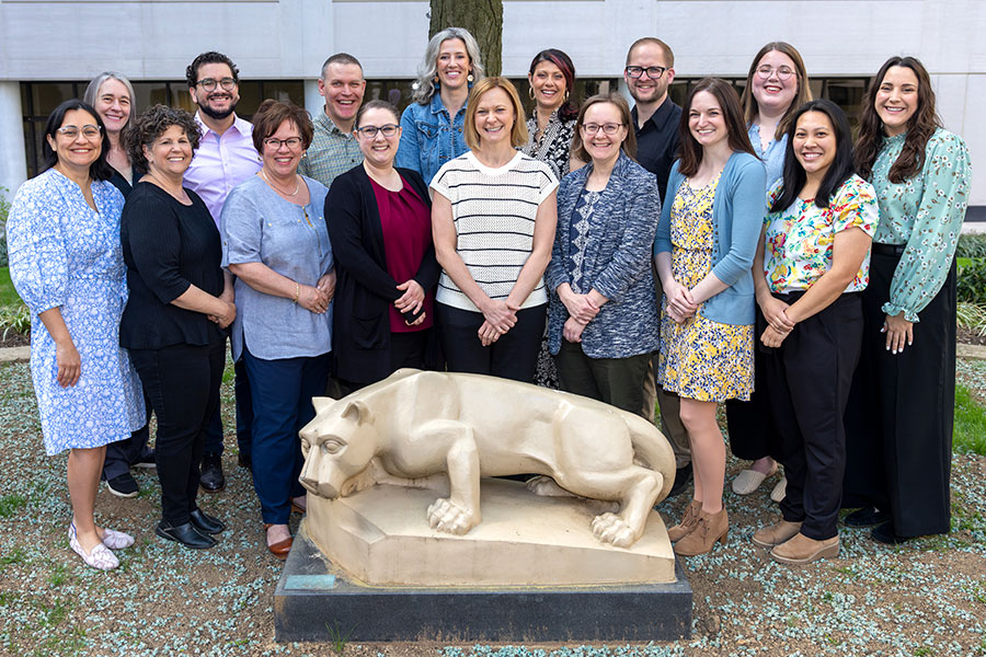 The palliative medicine care team pose around the Penn State Nittany Lion statue