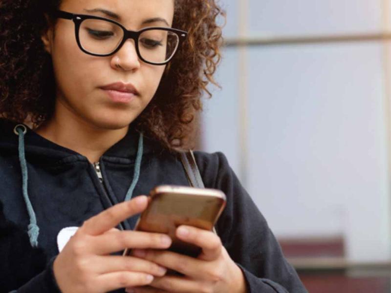 A young woman is using a mobile phone.