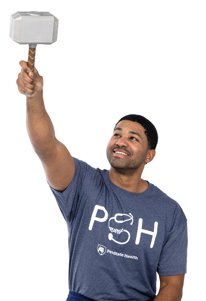 A male nurse is holding up a pretend mallet.