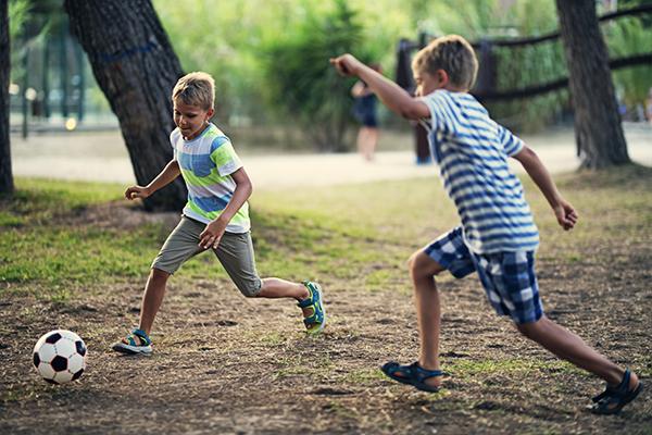 Two boys playing in city park.