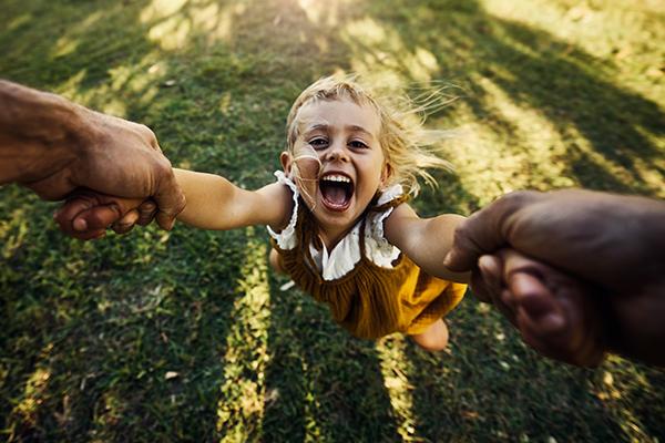 Shot of an excited little girl being spun around in the air by her unidentifiable father.