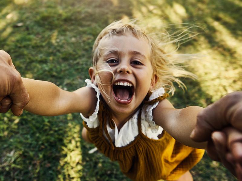 Shot of an excited little girl being spun around in the air by her unidentifiable father.