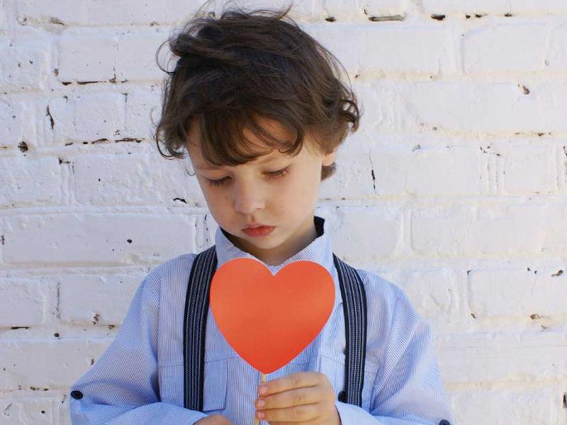 Photo of Boy Holding Heart-shape Paper on Stick