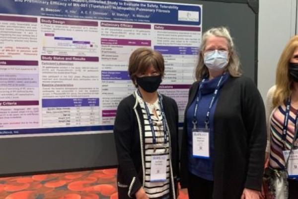 Rebecca Bascom and two colleagues pose for a photo in front of a poster board. They are wearing masks.