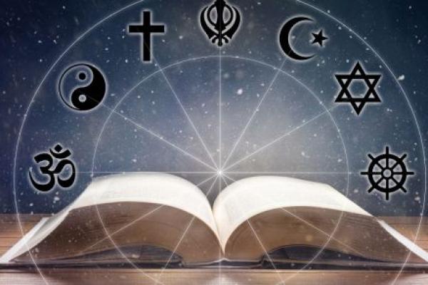 Book open to middle under a light from above. Overlaid, circle containing seven icons images representing the major religions of the world.