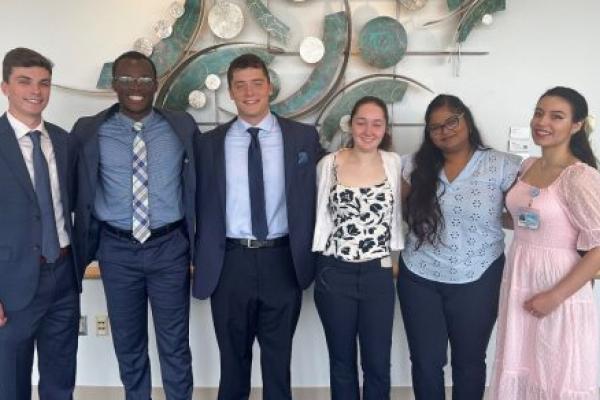 Six people pose for a photo together.