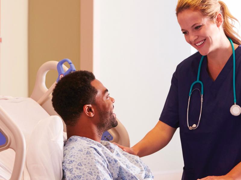 Nurse talks to a patient in bed