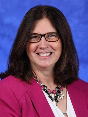 Michele Szkolnicki, in a professional head and shoulders photograph.