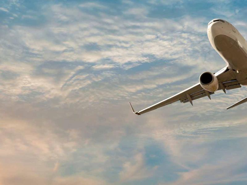 Mid-sized passenger airplane flying above clouds.